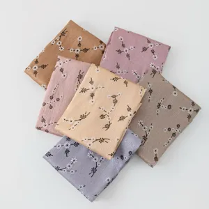 Detailed view of pleated silk-feel scarves with delicate floral prints, multi-color assortment.
