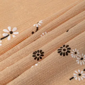 Detailed view of a stylish floral printed silk scarf showing delicate daisy patterns and soft texture.