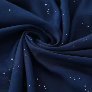 Gedetailleerde close-up van donkerblauwe sterren pailletten voile stof met glitters.