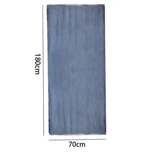 Vue détaillée de l'écharpe unie en coton et lin bleu, montrant les franges et la texture.
