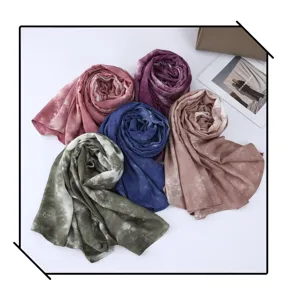 Detailed view of multiple rolled gradient tie-dye rayon fashion scarves in various vibrant colors.