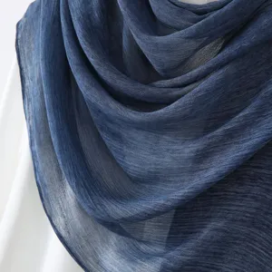 Gros plan d'un châle pour femme en lin et coton bleu foncé, montrant sa texture douce.