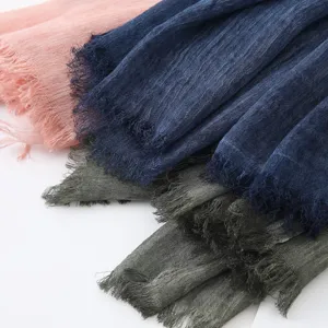 Détail d'écharpe en lin et coton avec bords frangés en plusieurs couleurs élégantes.
