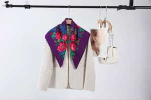 Detail shot of the vintage purple floral square scarf draped on a chic beige blazer display.