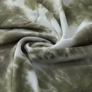 Close-up detail showing the soft texture and green gradient tie-dye pattern of the fabric.