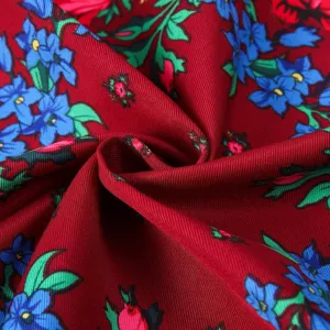 Retro floral printed square scarf fabric detail showing vibrant blue flowers on red.