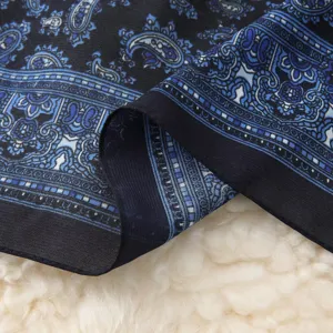 Detailed close-up view of the blue and black paisley patterned scarf fabric texture.