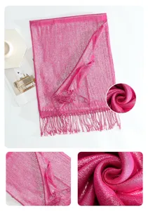 Detail view of a shimmering metallic pink tassel shawl, showcasing soft fabric texture and elegant drape.