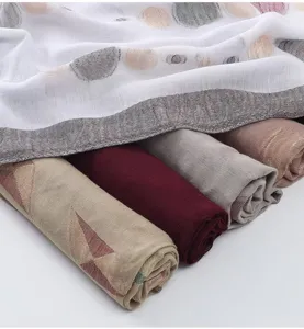 Detailed view of fashionable cotton linen printed scarves in rolled styles, soft texture.