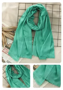 Green cotton linen scarf detail close up view, soft solid color shawl texture display.