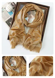 Detailed view of shimmering gold metallic long scarf with fringe, elegant fabric texture.