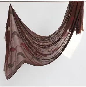 Brown cotton linen scarf with cut flower design and fringe details, elegant shawl hanging.