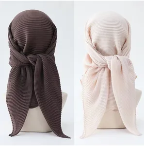 Pleated headscarf detail view showing back knot and texture of solid color square hijab.