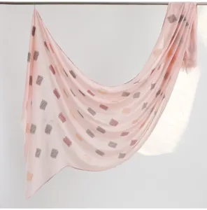 Pink linen cotton fringed scarf detail showing cut flower print and soft draped fabric texture.