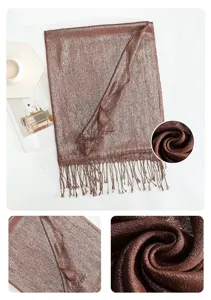 Detail view of a shimmering metallic long fringe scarf, showing soft fabric texture and elegant folds.