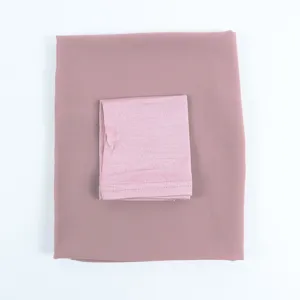 Detailed view of chiffon hijab and inner cap set in dusty pink, soft textile texture.