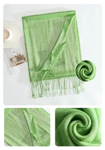 Green glitter scarf close-up detail, featuring sparkling metallic fabric and elegant fringe trim.