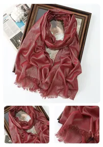 Detailed view of women metallic glitter long scarf, shimmering fabric texture and fringe edge.