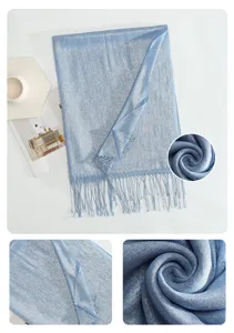 Detailed view of light blue shimmering metallic tassel scarf showing soft texture and fabric.