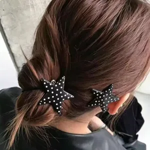 Detailweergave van zwarte ster haarspelden met witte stippen, schattige haaraccessoire stijl.