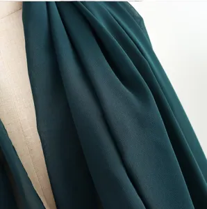 Vista dettagliata del foulard hijab in chiffon verde scuro unito, con morbida consistenza e drappo.