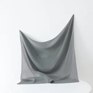 Detailed view of a solid grey pleated square scarf, showcasing fine texture and drape design.