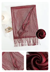 Detail view of the elegant metallic shiny red tassel scarf showing delicate texture close-ups.