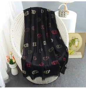 Black cotton linen scarf with metallic CD monogram pattern, elegant fringed shawl for women.