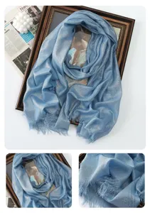 Close-up detail of shimmering light blue long scarf with delicate metallic threads and fringe.