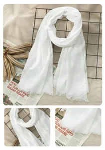 Detail view of the white cotton linen scarf showing fringe texture and fabric quality close up.