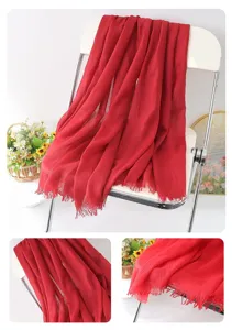 Detail view of red linen scarf showcasing soft fabric texture and delicate fringe edge design.