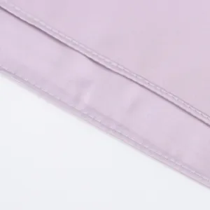 Close-up detail of smooth purple satin fabric with neat double stitching hem, texture view.