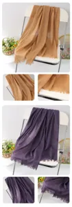 Detail view of solid color linen scarf showing delicate fringe texture and draped fabric.