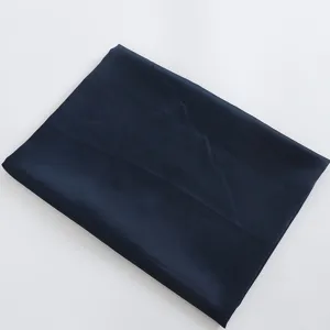 Detail view of the solid dark blue satin fabric, showing smooth texture for making.