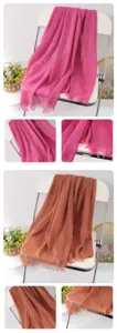 Detail view of solid color fringed linen scarves showcasing soft texture and delicate tassel edges.