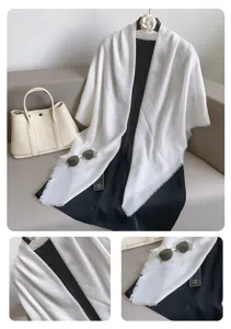 Gedetailleerd overzicht van elegante witte fransensjaal en zwarte jurk, zachte stof.