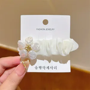 Detailed close-up of white mesh crystal flower duckbill hair clip, elegant side hair accessory.