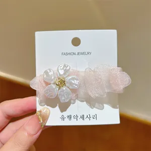 Exquisite pink mesh flower duckbill hair clip close-up showing fine pearl details on backing card.