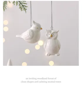 Primo piano dettagliato di simpatici ornamenti sospesi in ceramica di uccello e gufo per albero.