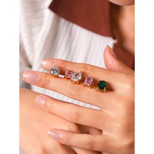 Close-up detail shot showcasing multi-shape colorful zircon stud earrings on fingers.
