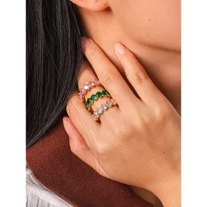 Detailed shot of stacking gold-plated stainless steel rings with colorful cubic zirconia.
