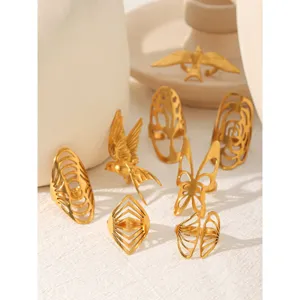 Close-up of gold stainless steel hollow rings featuring birds and butterflies for detail view.