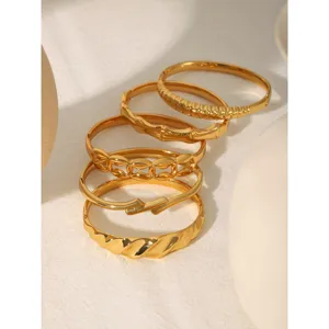Vue détaillée de bracelets rigides élégants en acier inoxydable doré 18k au design irrégulier.