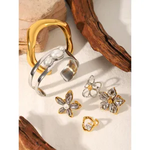Detail view of trendy two-tone stainless steel flower rings and bangles set, luxury style.