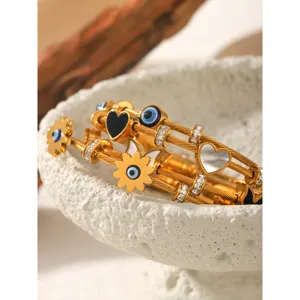 Goldene Titanstahl Kabel Armreifen mit bösem Blick und Schmetterlingsanhängern für Damen.