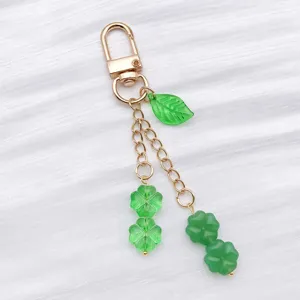 Detalle de accesorio llavero cuenta de vidrio trébol de cuatro hojas verde, dije DIY.