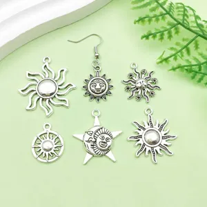 Gros plan de pendentifs et breloques soleil en alliage argent antique pour bijoux DIY.