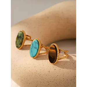 Detail of vintage stainless steel natural stone rings with tiger eye and turquoise stones.