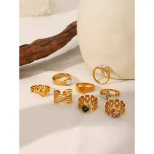 Gold stainless steel ring set detail showcasing unique geometric and pearl designs.