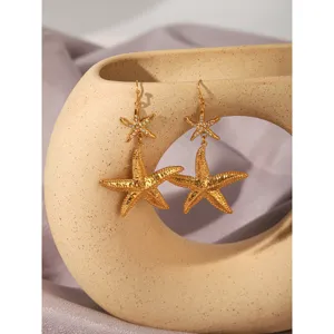Detailed close-up of double-layer golden starfish earrings with crystal rhinestones.